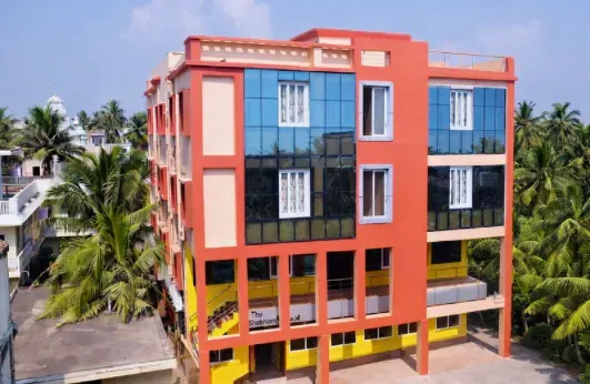 The hotel façade, framed by palms off C.T. Road